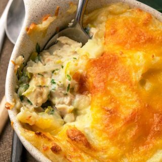 Closeup of fish pie with leeks in a serving dish.