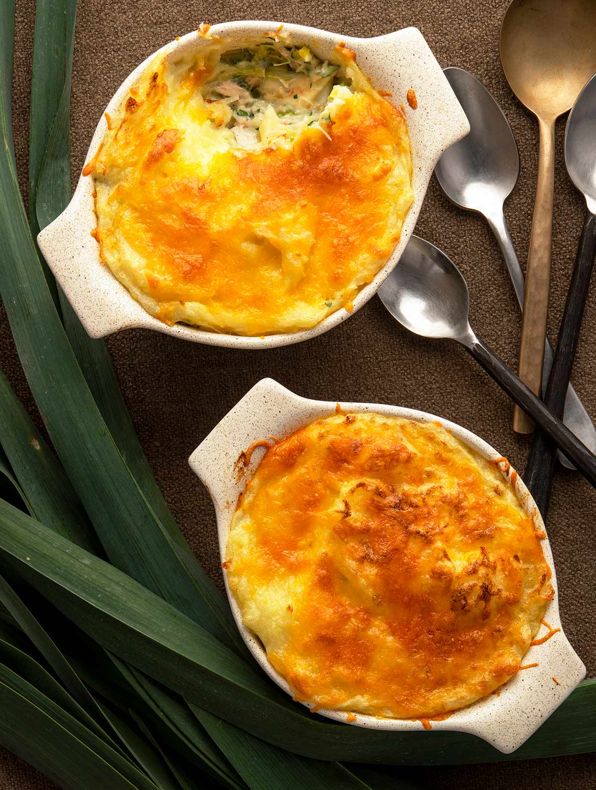 Two servings of fish pie with leeks on a table. 