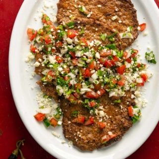 Mexican pacholas on a platter with pico de gallo salsa.