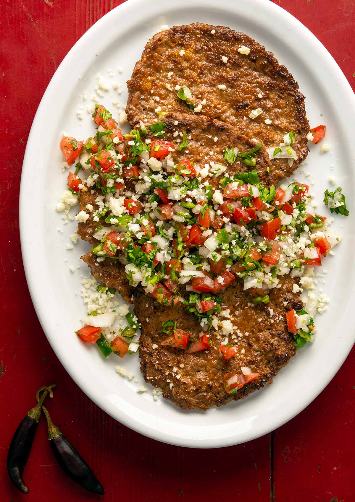 Mexican pacholas on a platter with pico de gallo salsa.