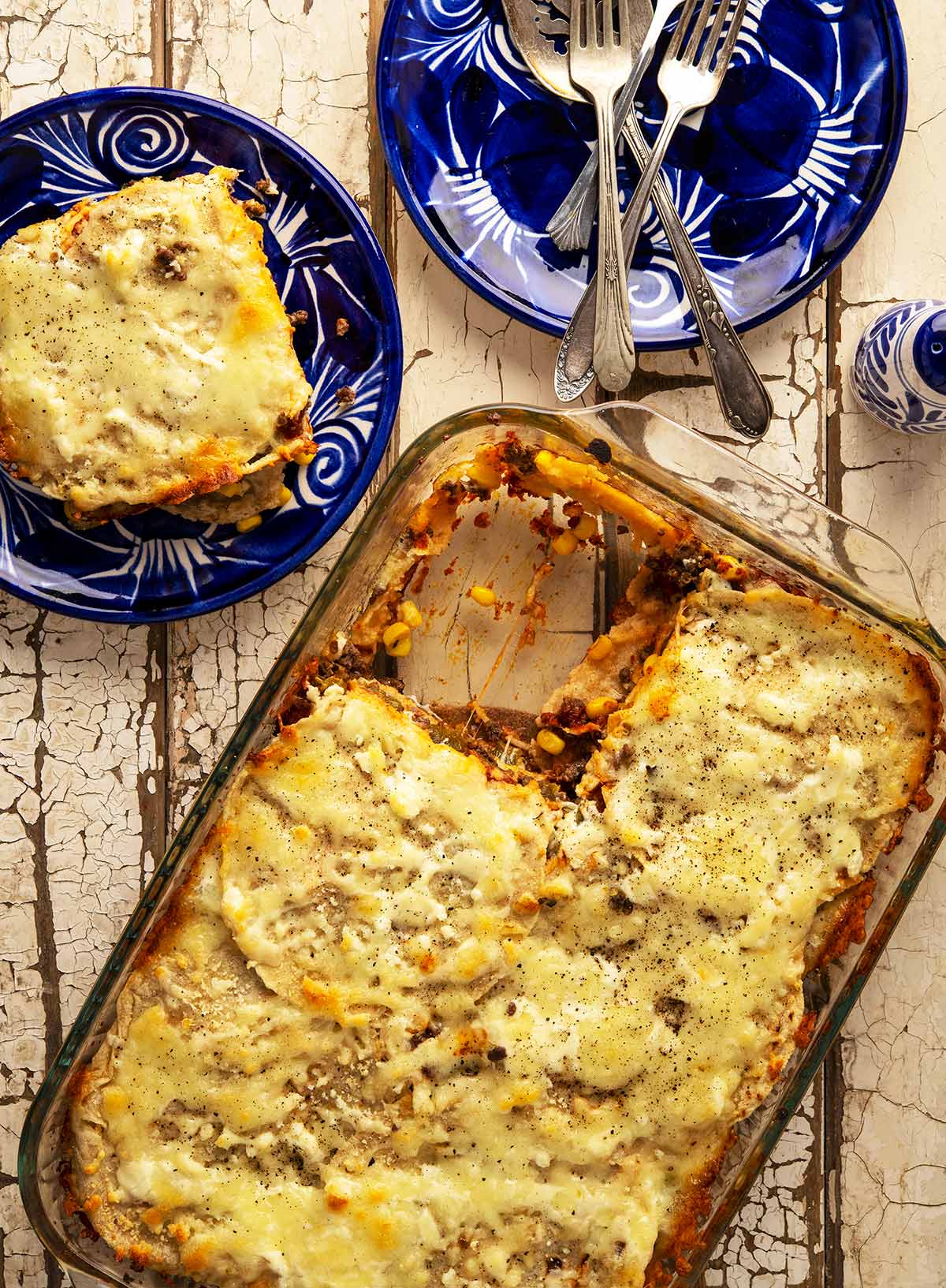 A casserole of pastel azteca with one portion taken out. 