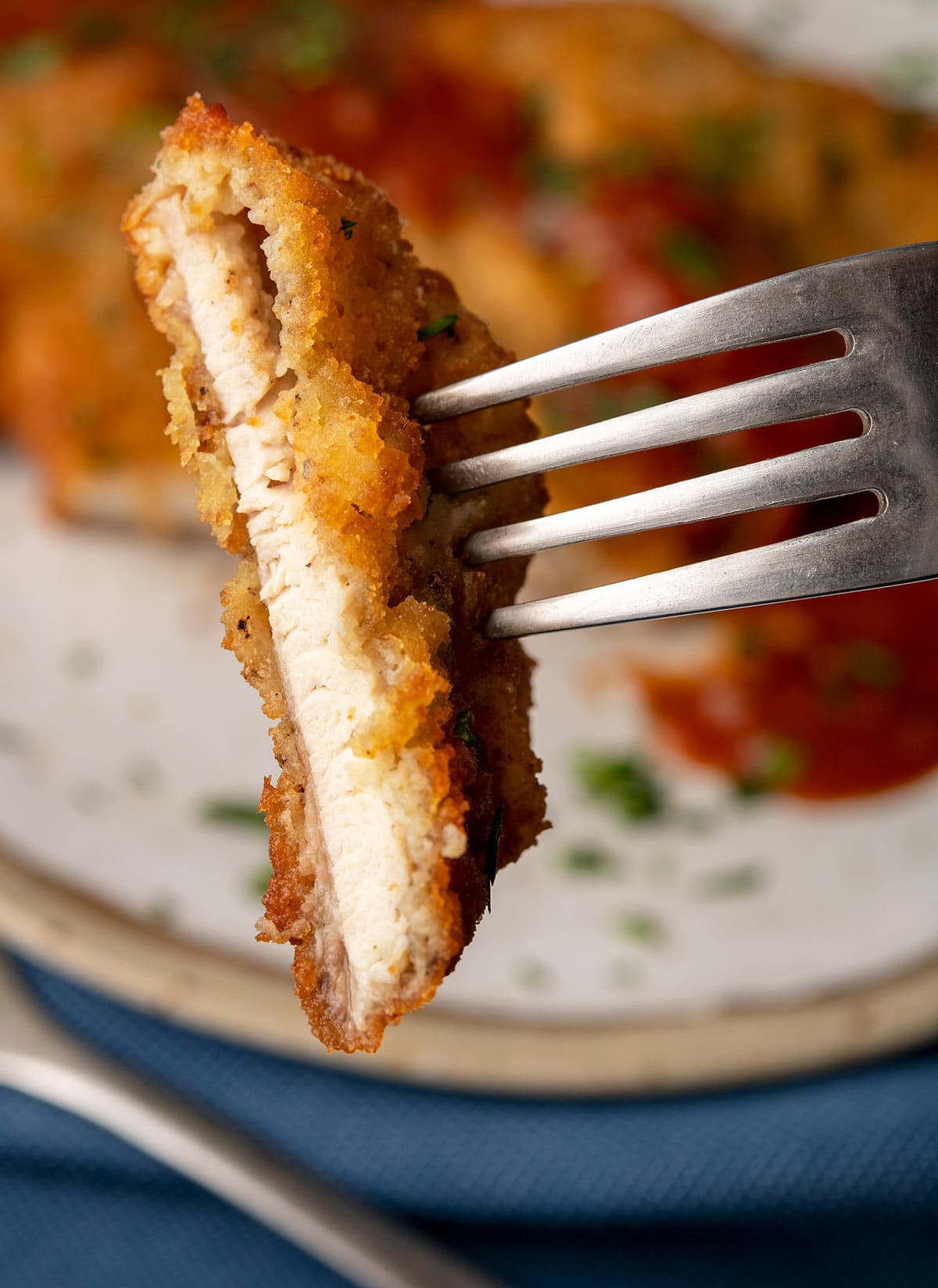 Holding up a slice of turkey schnitzel to show the breading. 