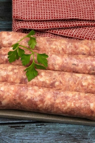 Four links of Toulouse sausage on a cutting board.