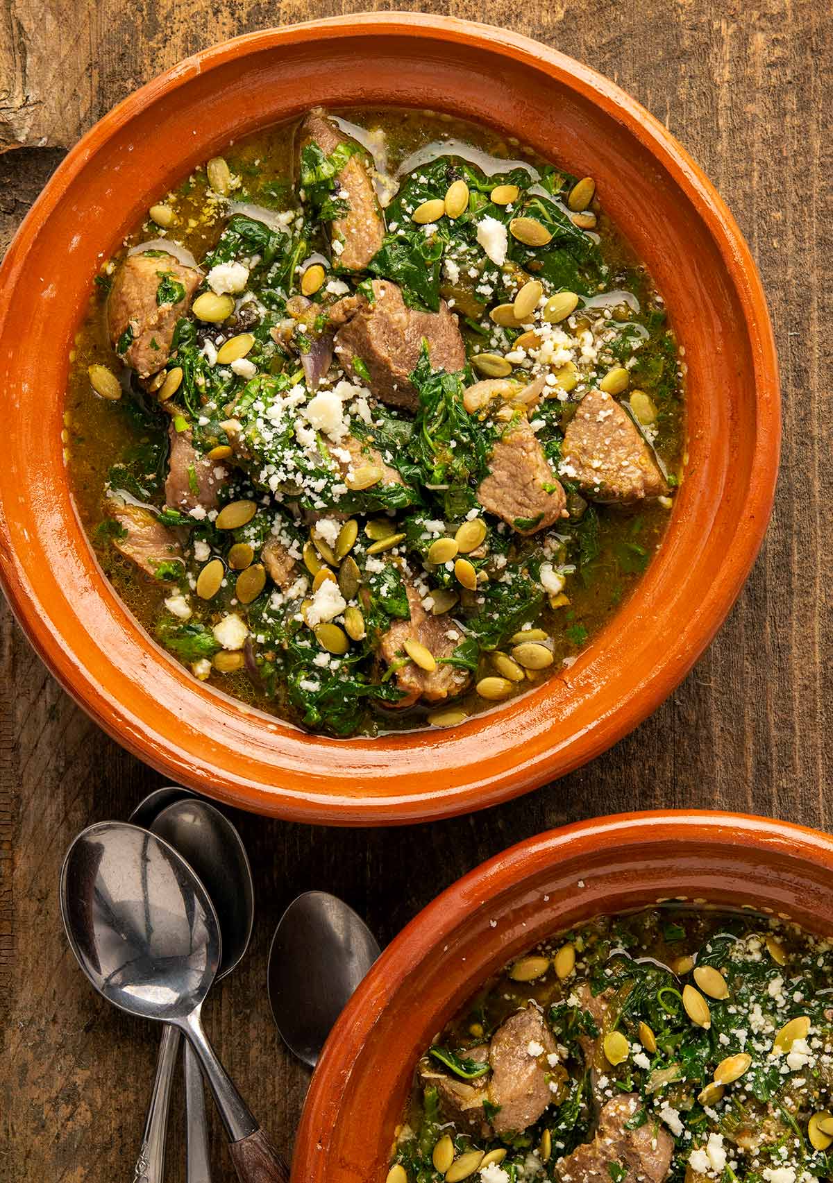 Two bowls of amaranth greens with pork. 