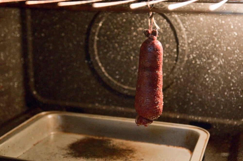 A goose neck sausage roasting in the oven. 