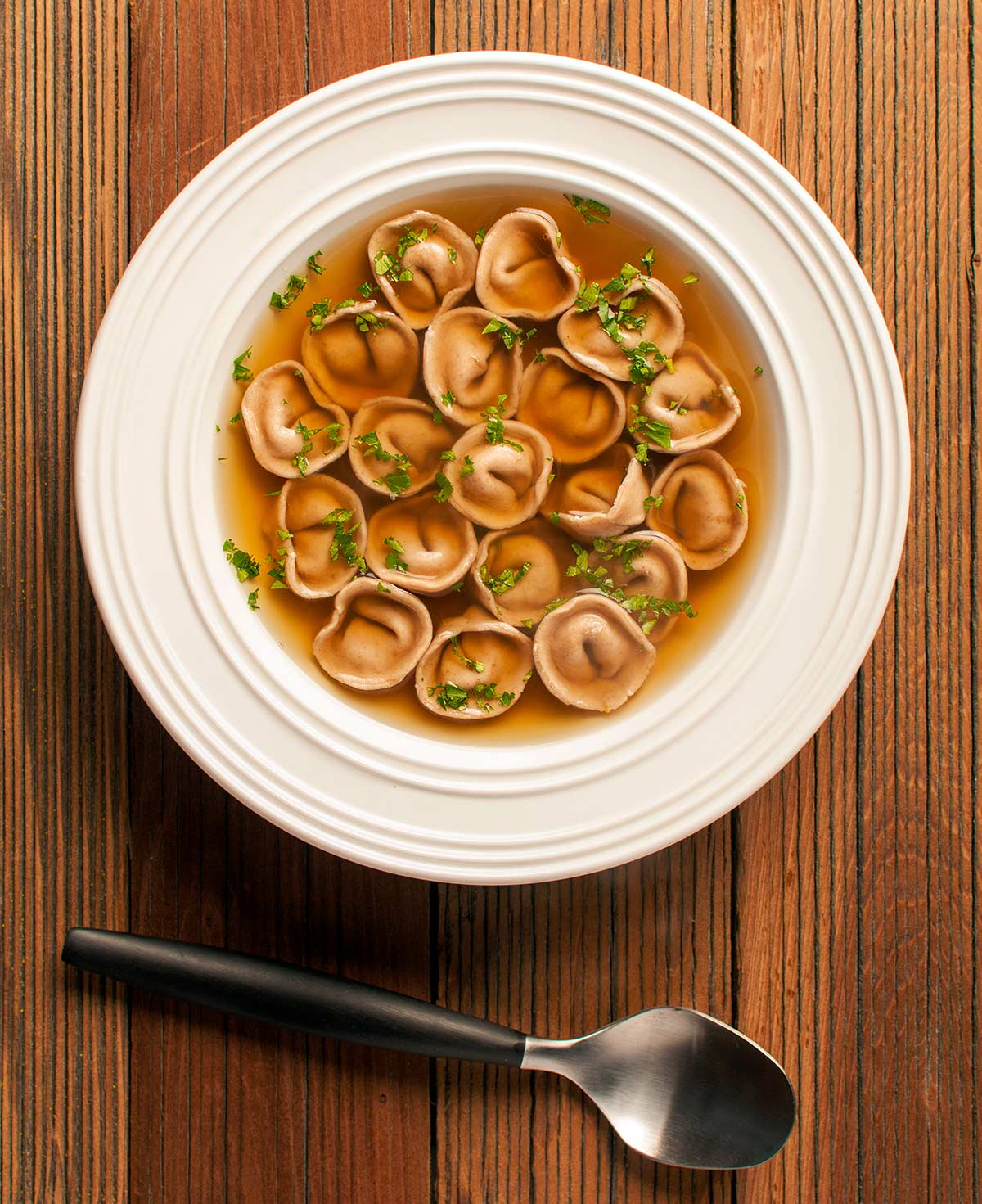 A bowl of cappelletti pasta swimming in duck stock. 