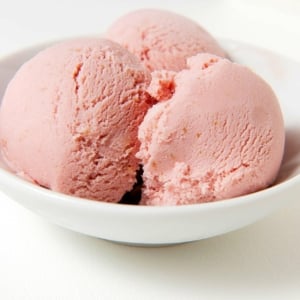 Three scoops of elderberry ice cream in a bowl.