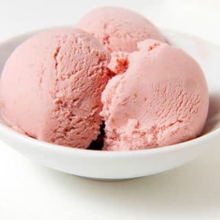Three scoops of elderberry ice cream in a bowl.