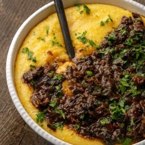 Closeup of a bowl of polenta with mushroom ragu.