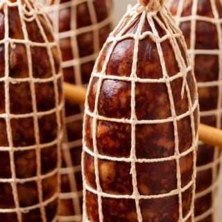 Wild boar salami netted and hanging to dry.