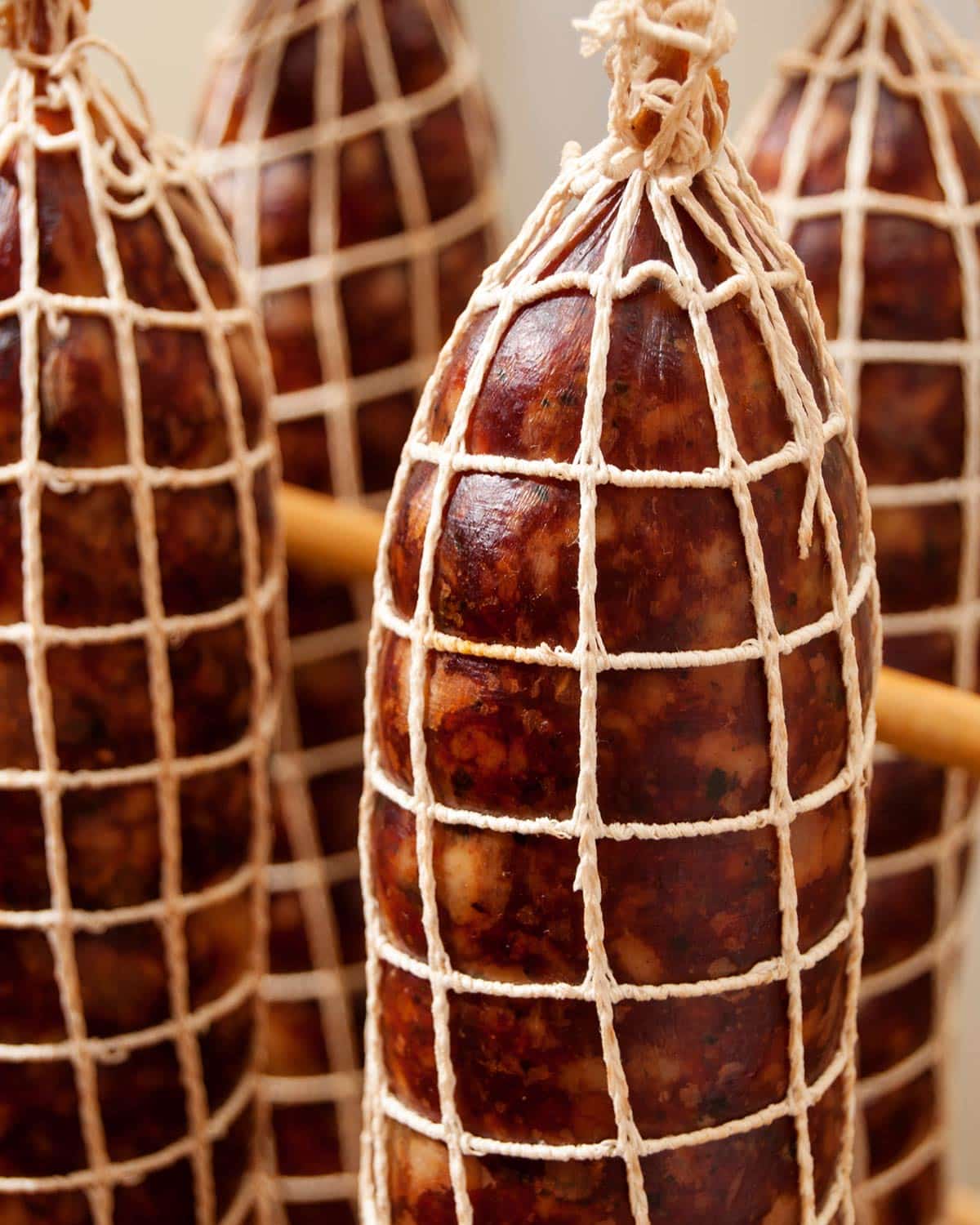 Wild boar salami netted and hanging to dry.