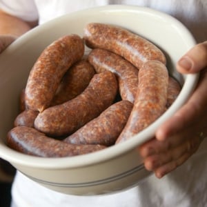 Hank Shaw holding a bowl of sausage with sage.