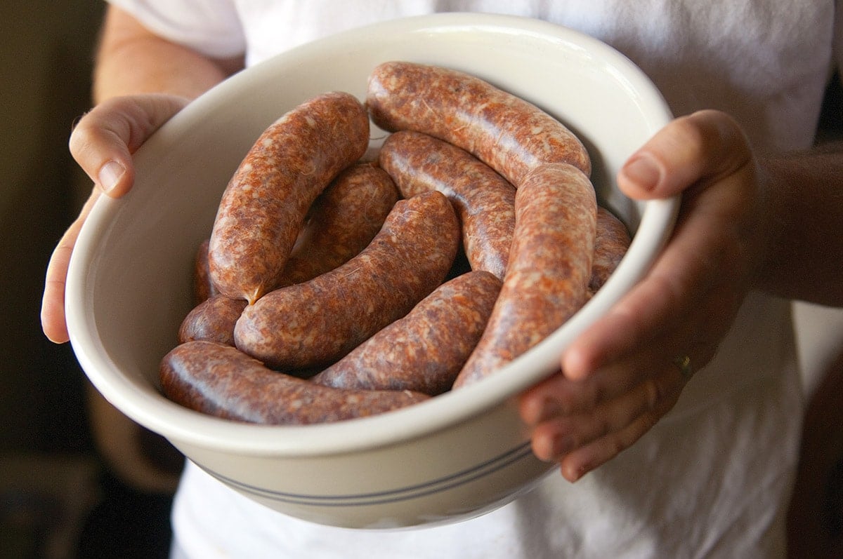 Hank Shaw holding a bowl of sausage with sage.