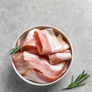 Slices of unsmoked bacon in a bowl.