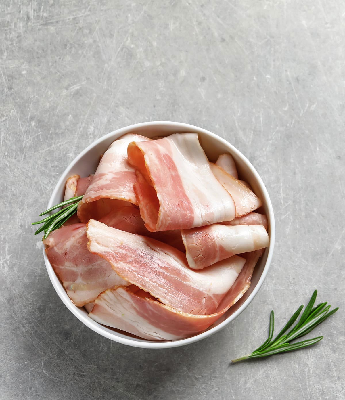 Slices of unsmoked bacon in a bowl. 