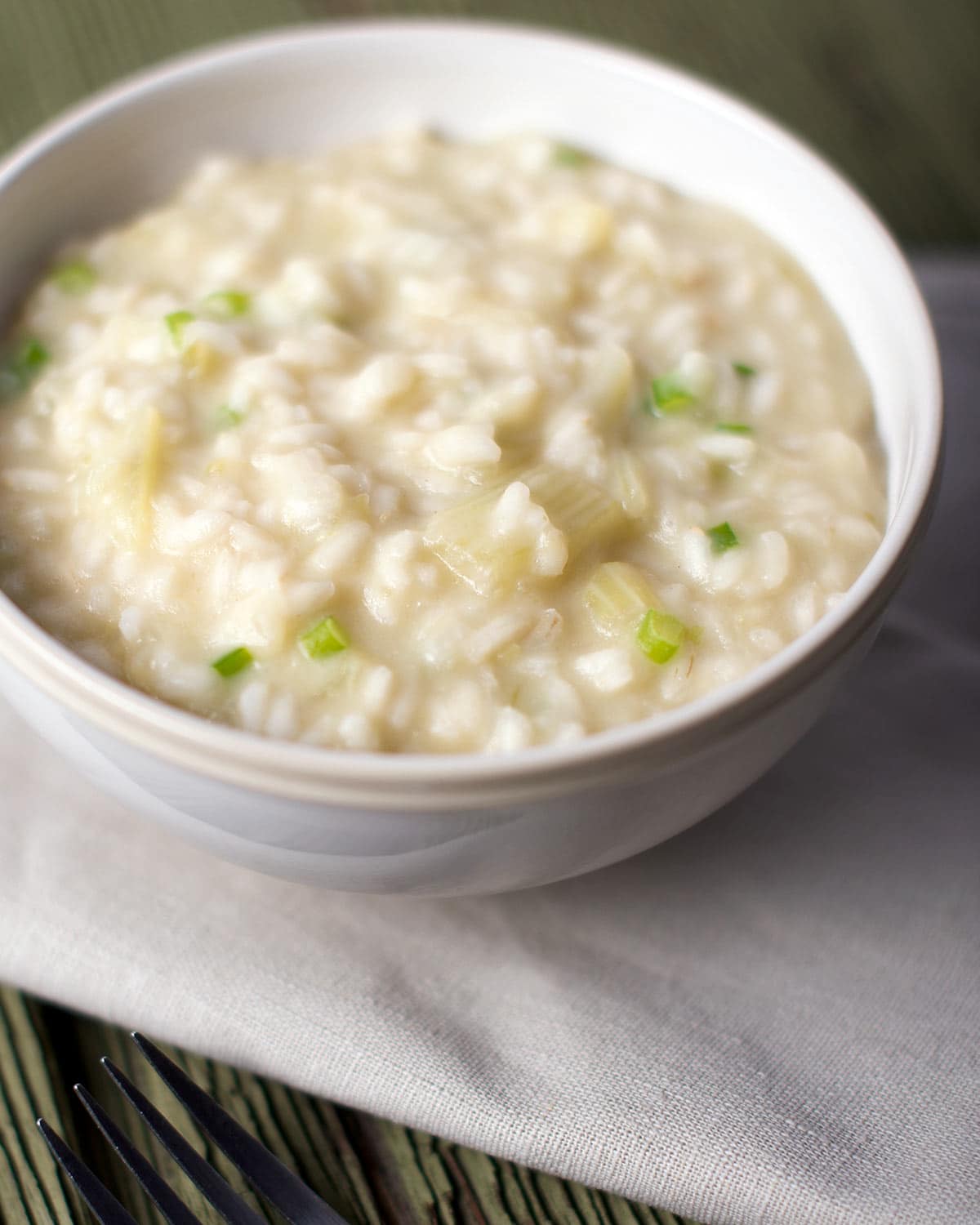 A bowl of cardoon risotto on a napkin. 