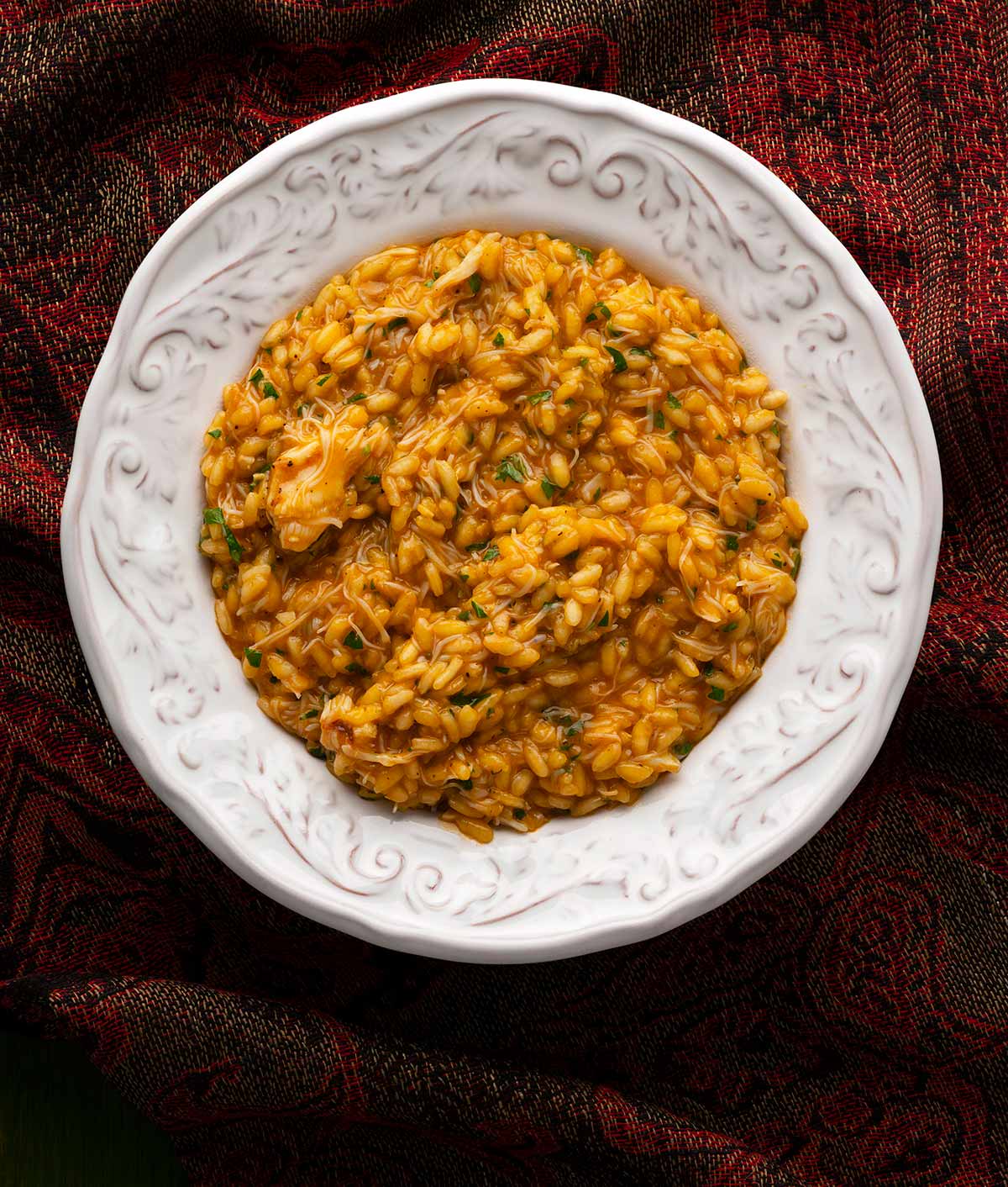 A bowl of crab risotto with tomato. 
