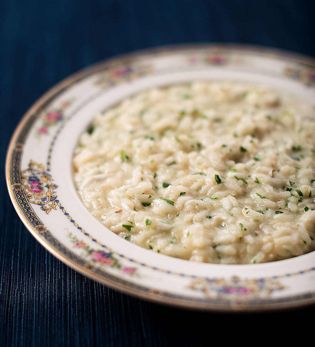 A bowl of fish risotto on a silk tablecloth. 