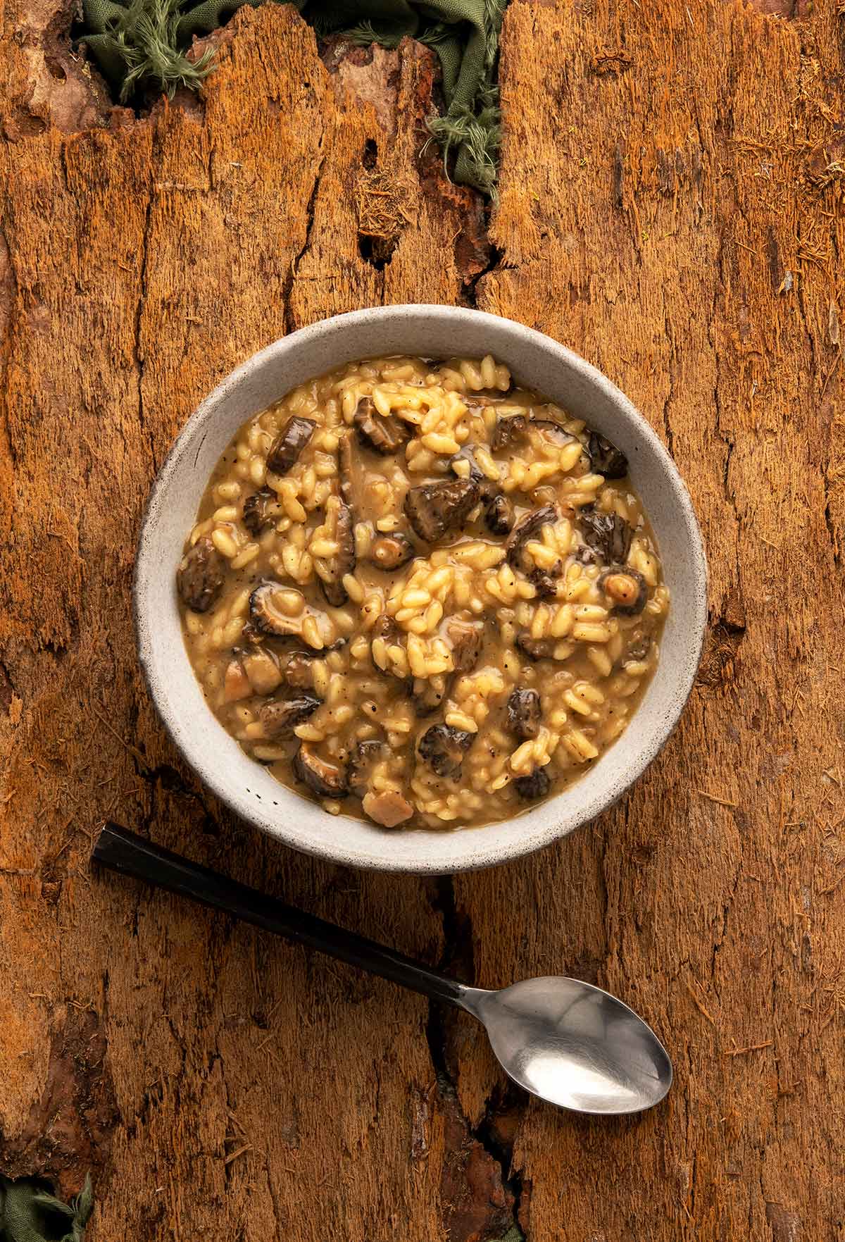 A bowl of mushroom risotto on a wooden table. 