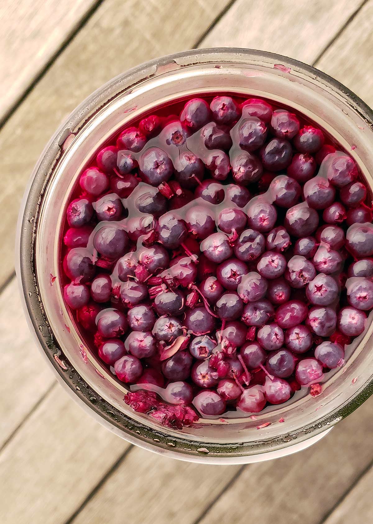 A jar pf pickled blueberries from above.