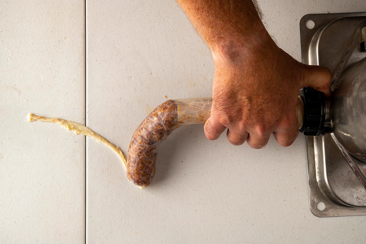 Stuffing homemade sausage with a hand stuffer.