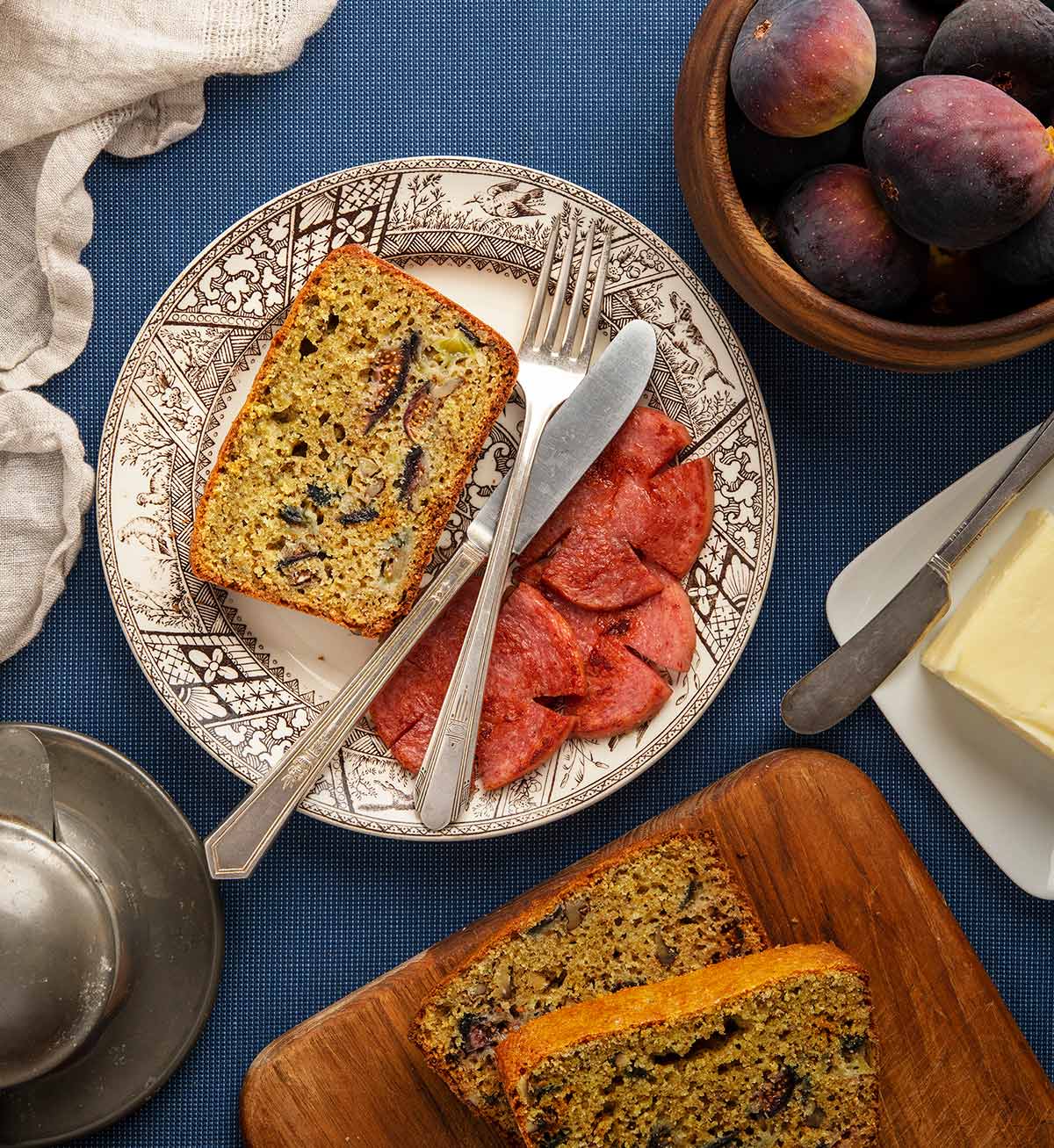 Overhead view of a slice of fig bread on a plate with Taylor ham. 