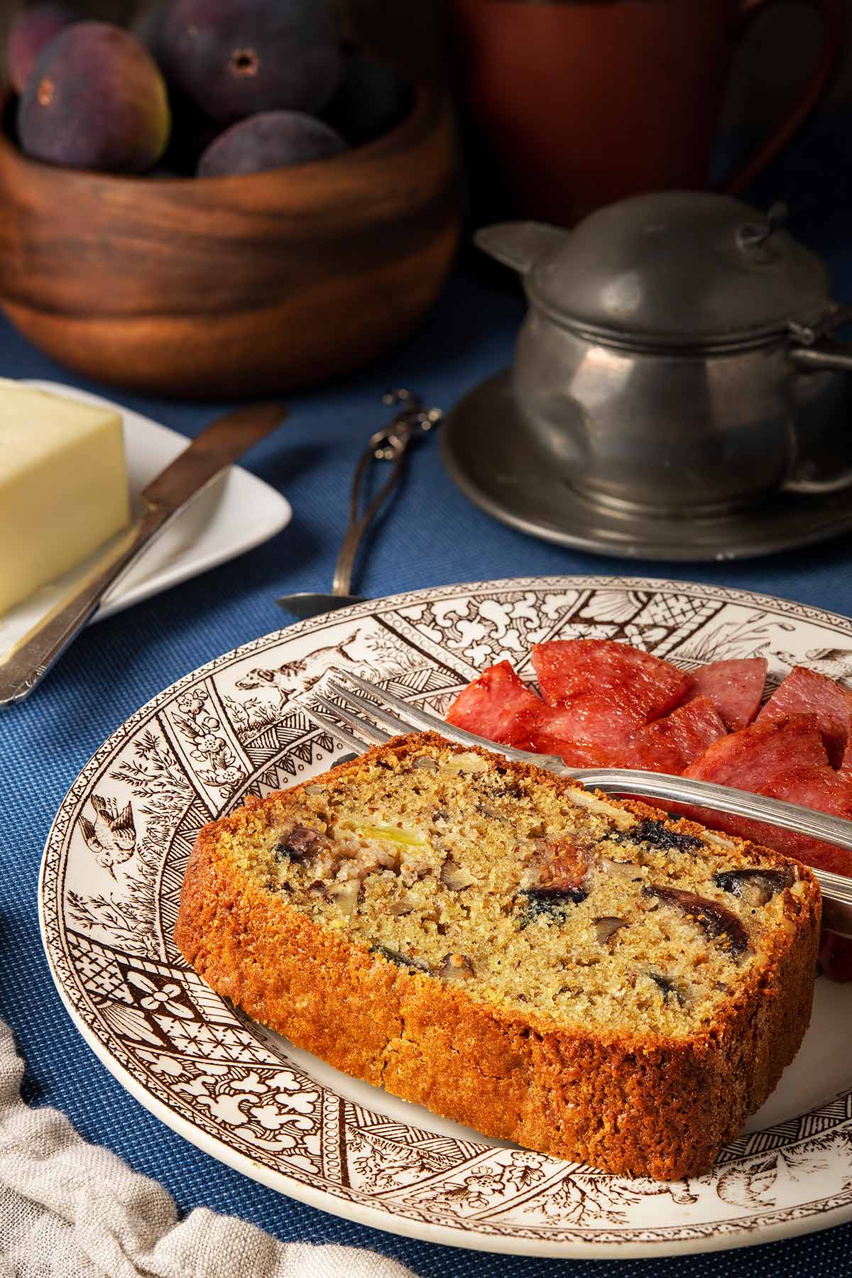 A slice of fig bread on a plate with Taylor ham.