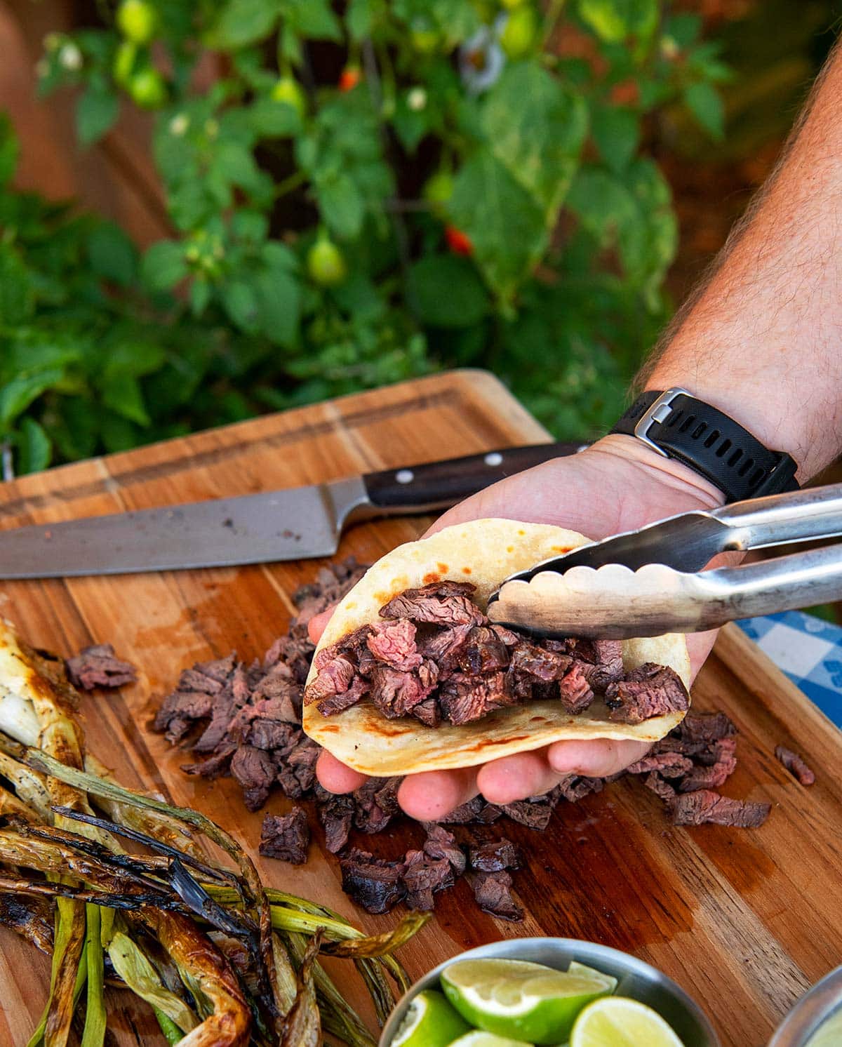 Filling a flour tortilla with chopped venison for carne asada tacos. 