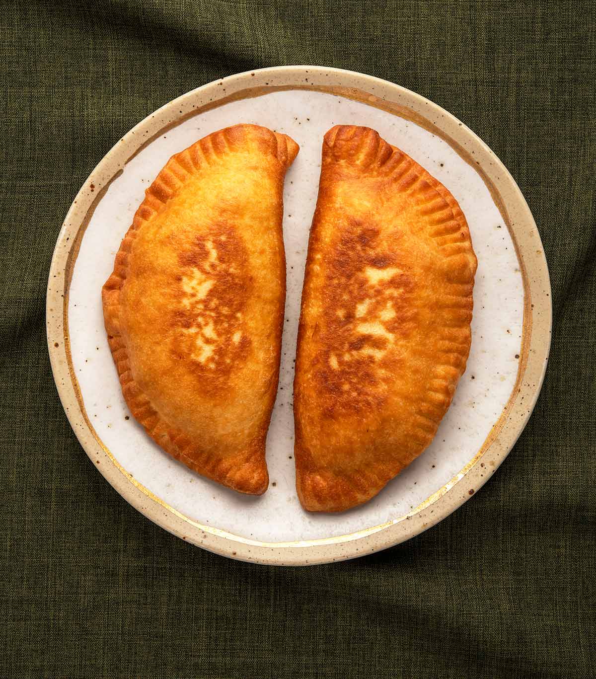 Two lihapiirakka, Finnish meat pies, on a plate. 