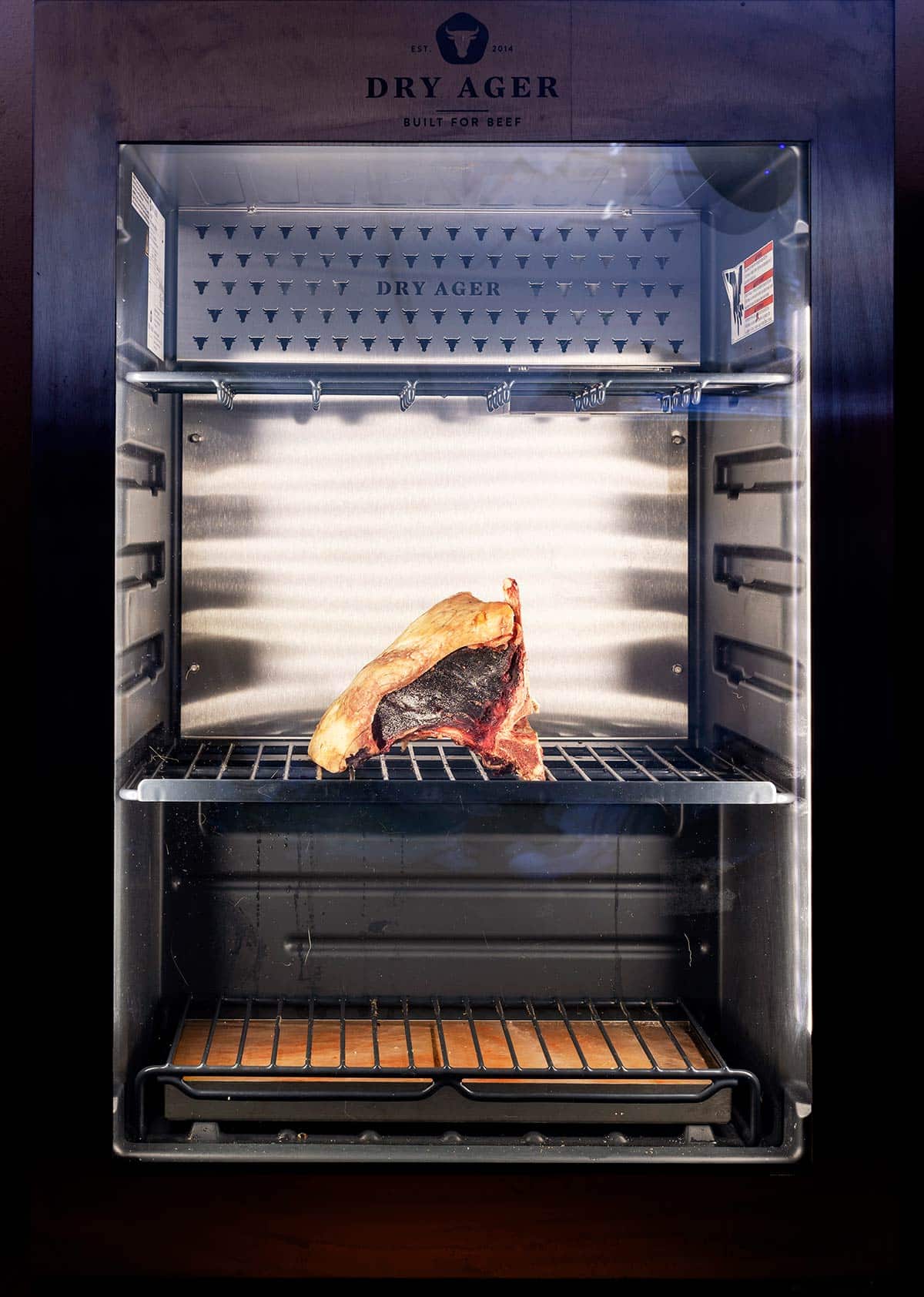 A bison steak dry aging in a cooler. 