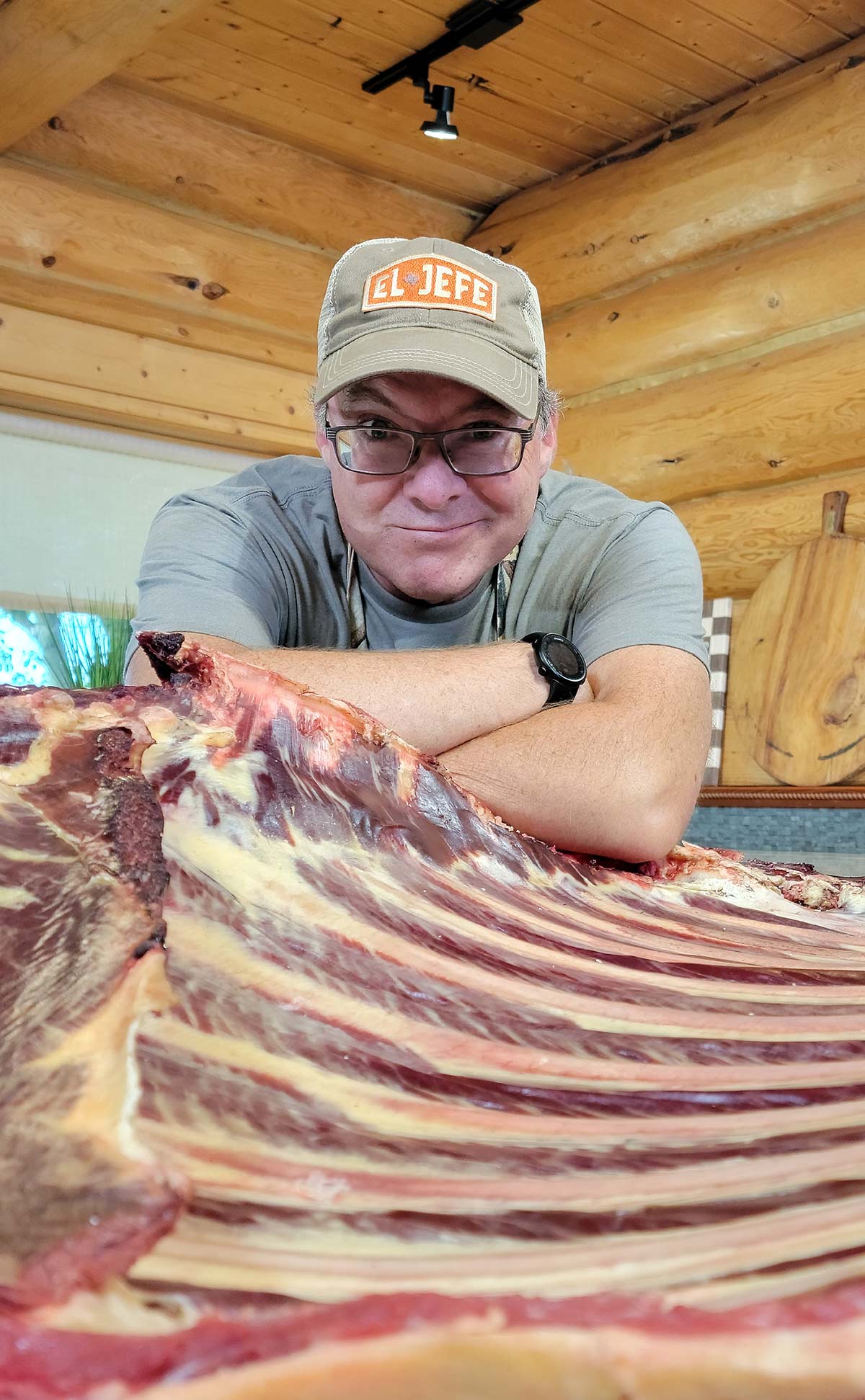 Hank Shaw smiling over a rack of bison ribs. 