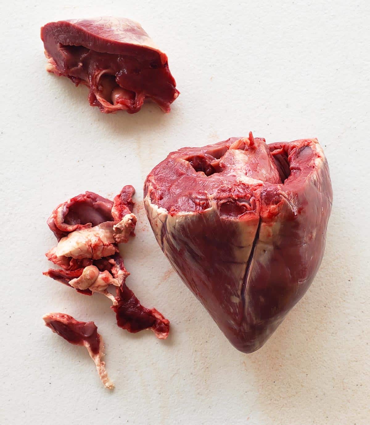 A deer heart trimmed at the top, and with the hard fat removed from the outside of it.