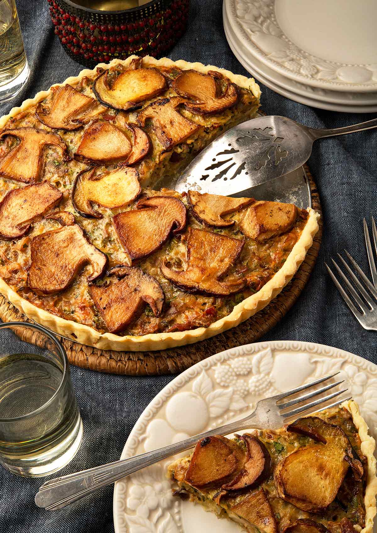 A mushroom tart with a wedge cut out of it, ready to eat. 