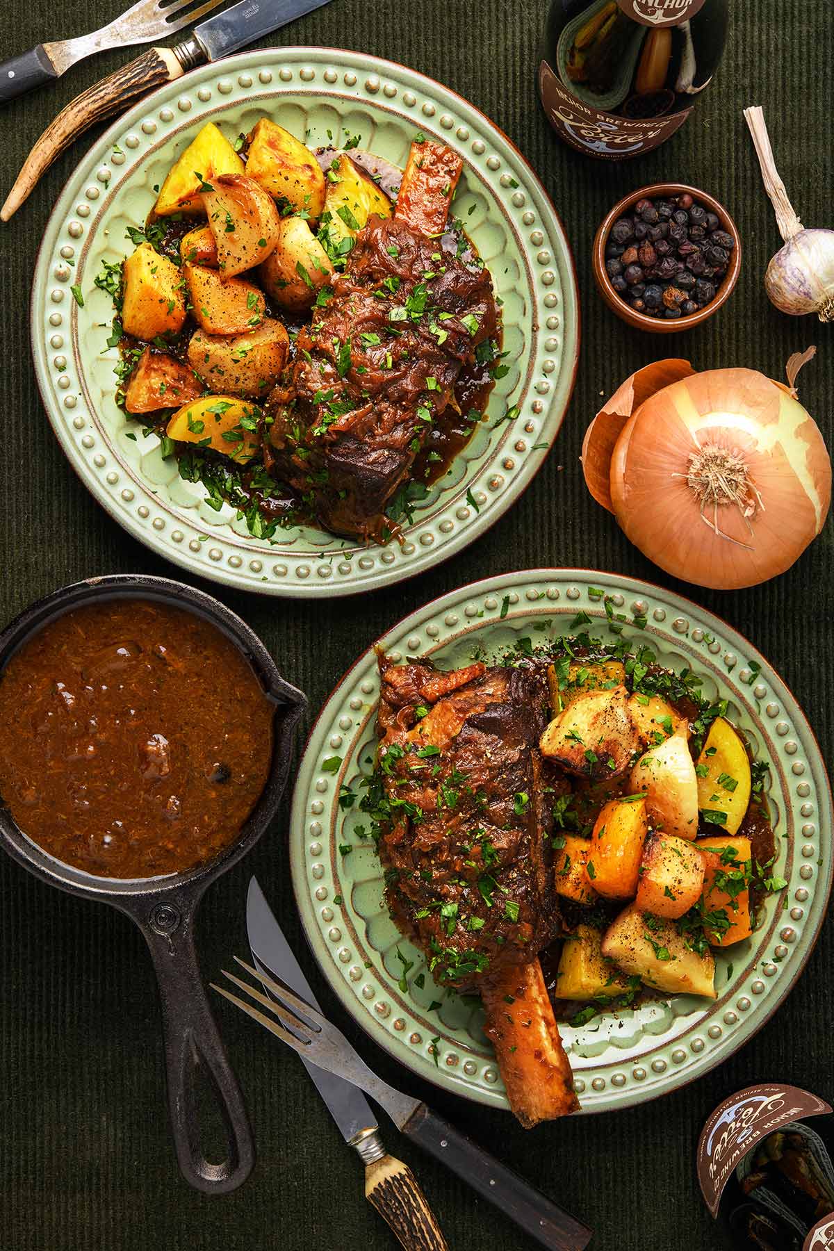 Two plates of beer braised short ribs with root vegetables and sauce on the side. 