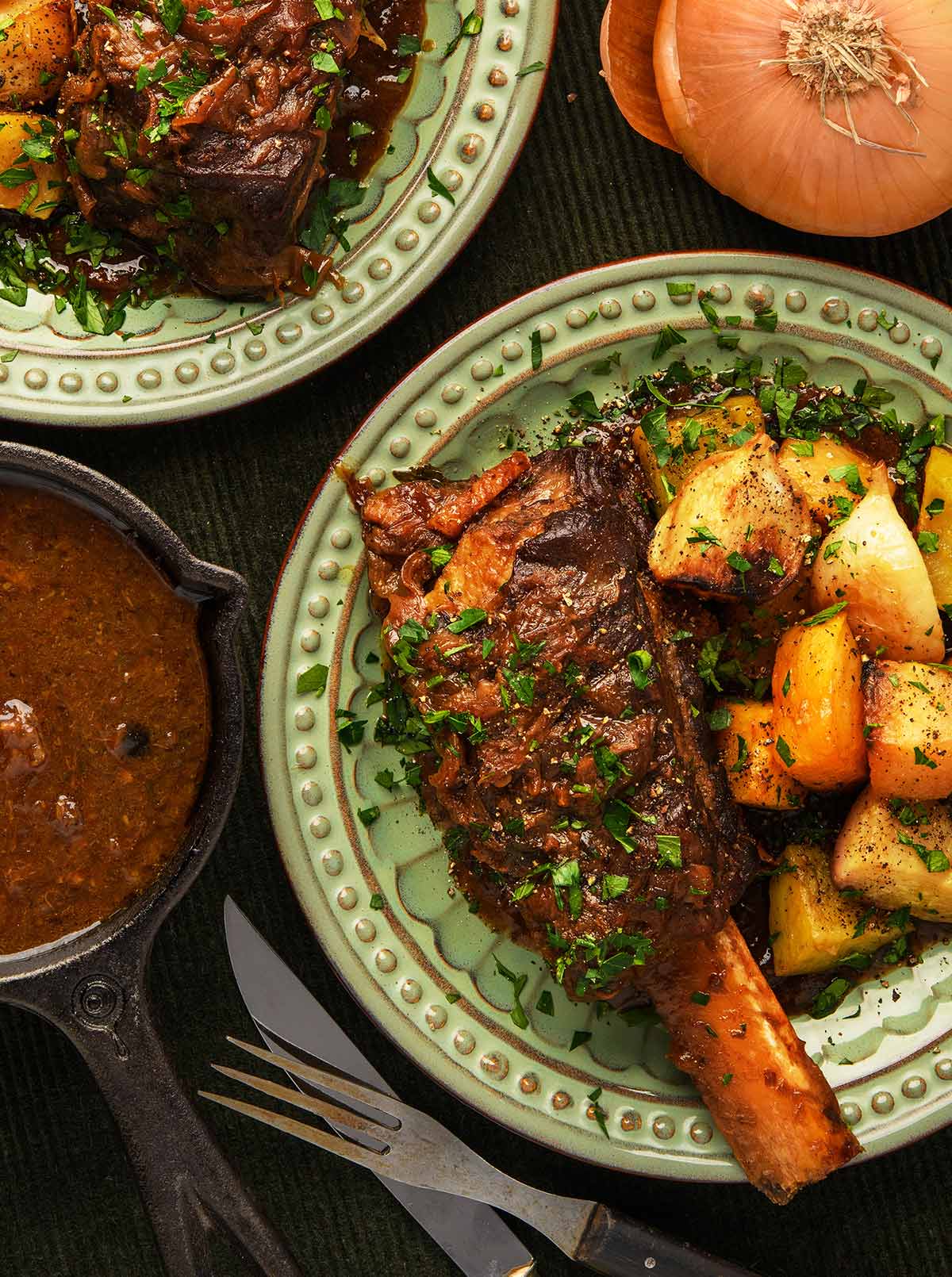 Beer braised bison short ribs on a plate with root vegetables. 