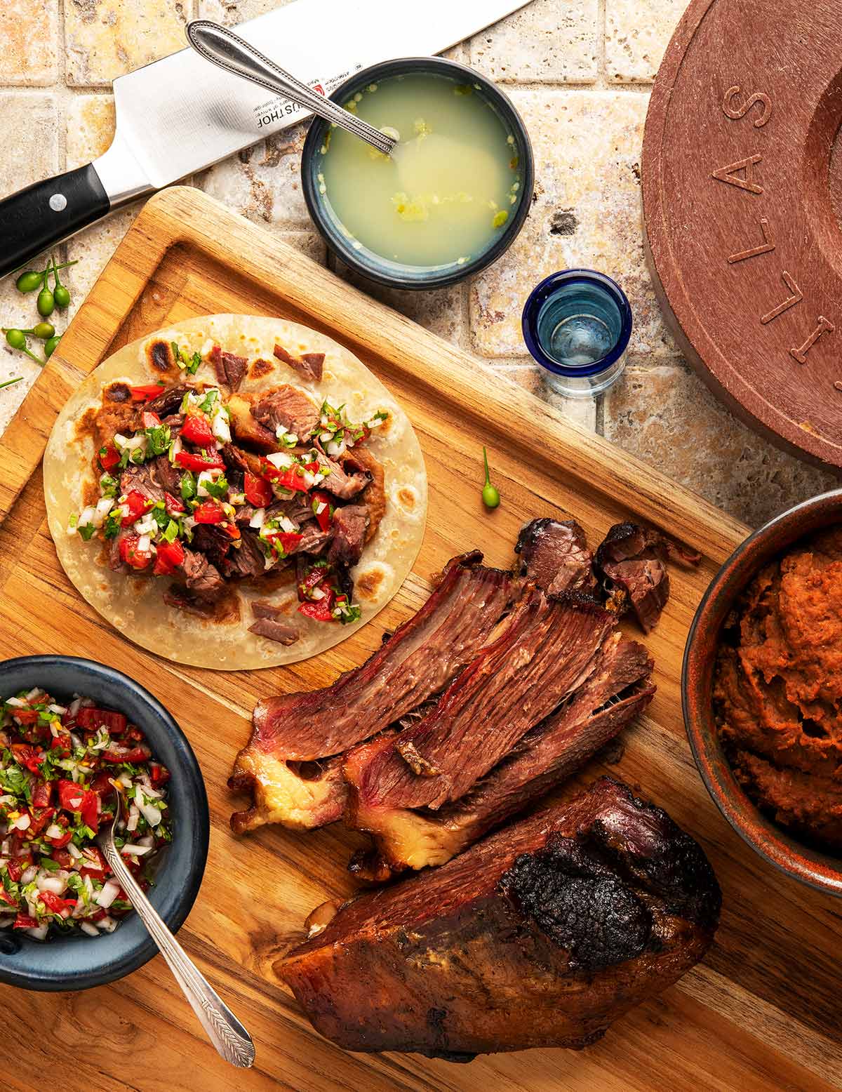 A brisket taco with slices of brisket and salsas all around. 