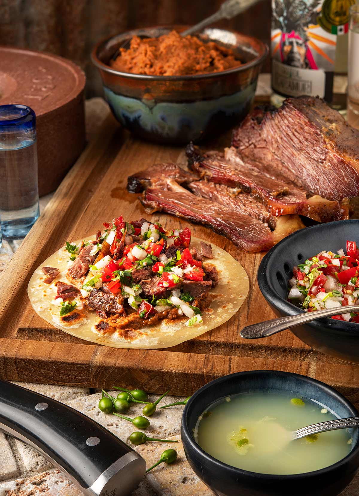 Brisket tacos with all the fixins on a cutting board. 