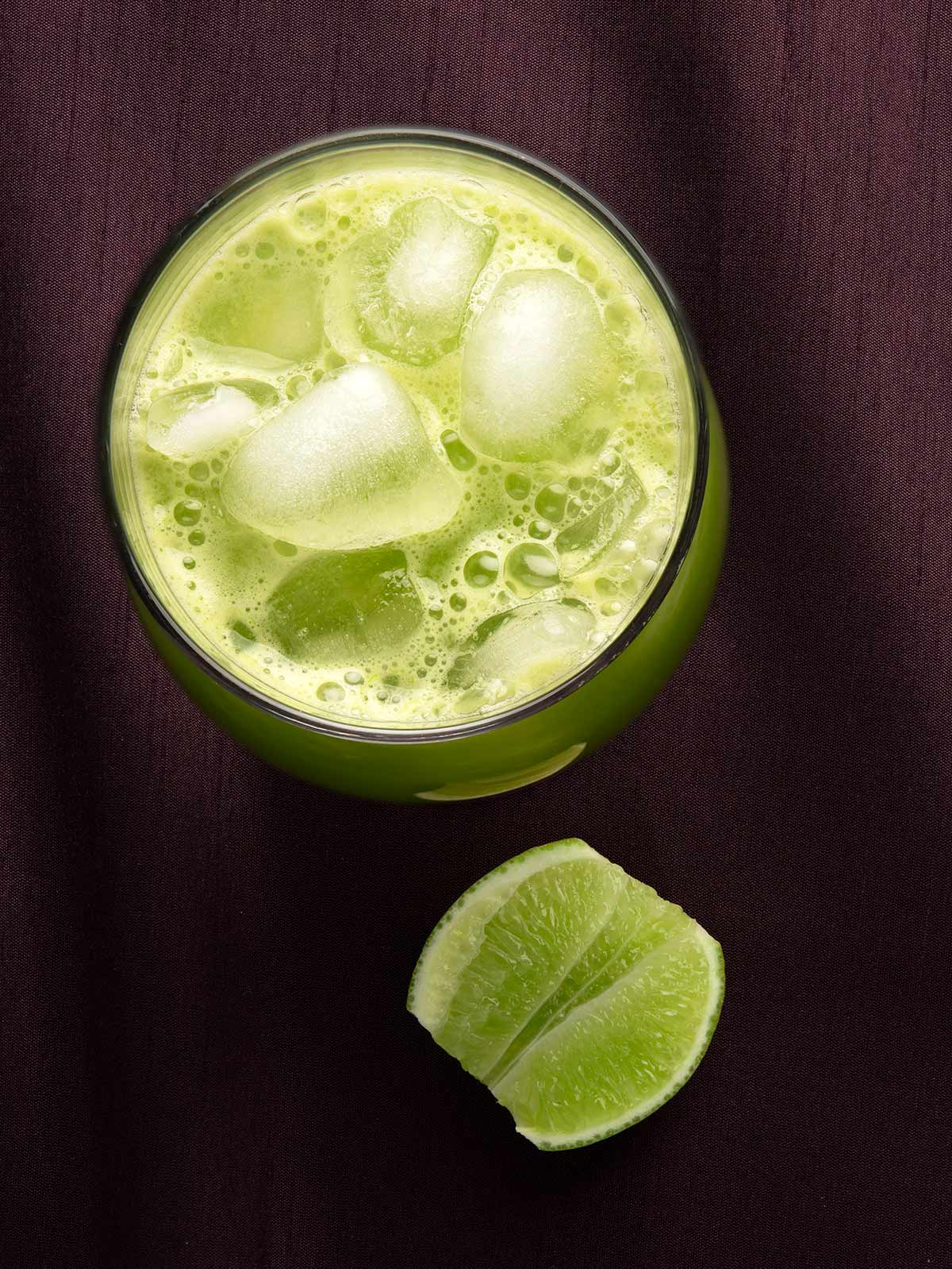 Overhead view of a glass of cucumber agua fresca. 