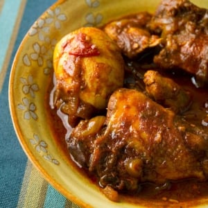 Close up of a bowl of doro wat, with a hard-boiled egg.