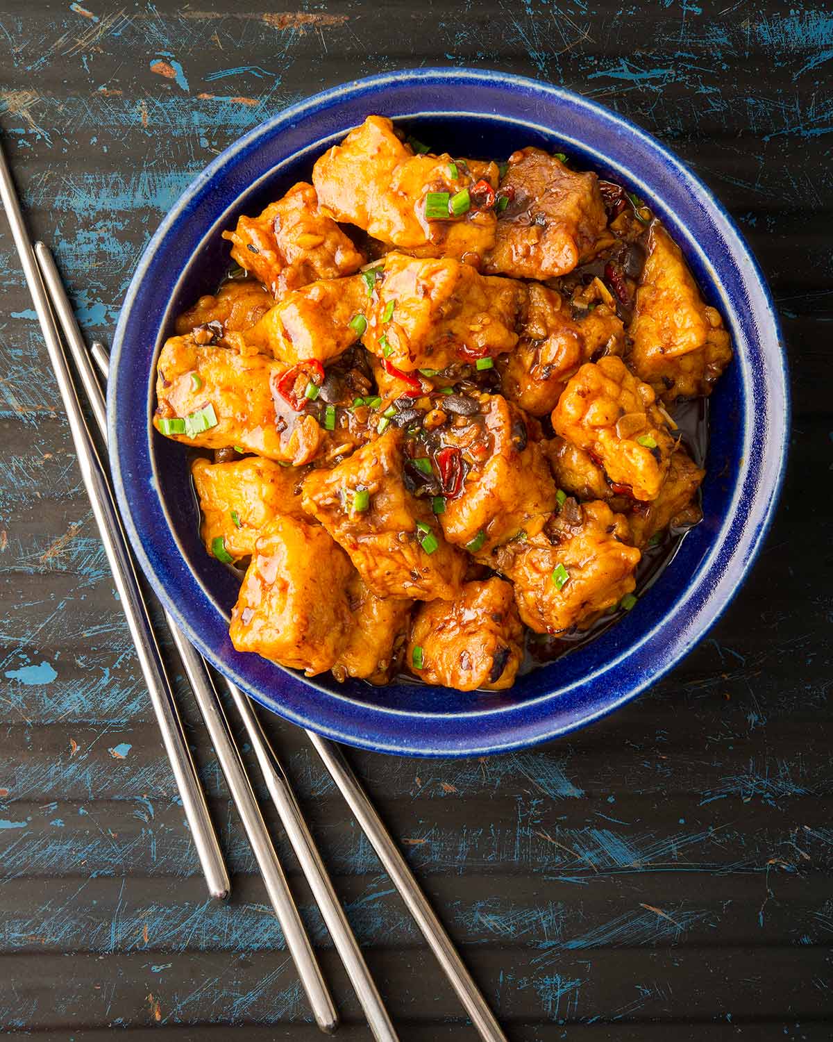 A plate of fish stir fry with chopsticks. 