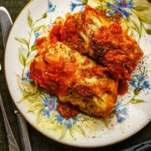 Close up of two Polish cabbage rolls with tomato sauce.