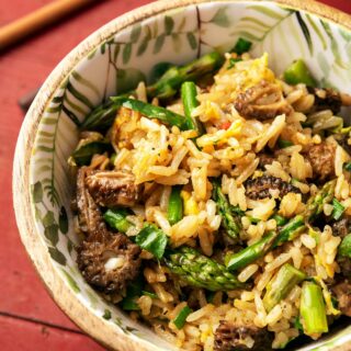 Close up of a bowl of mushroom fried rice with morels and asparagus.