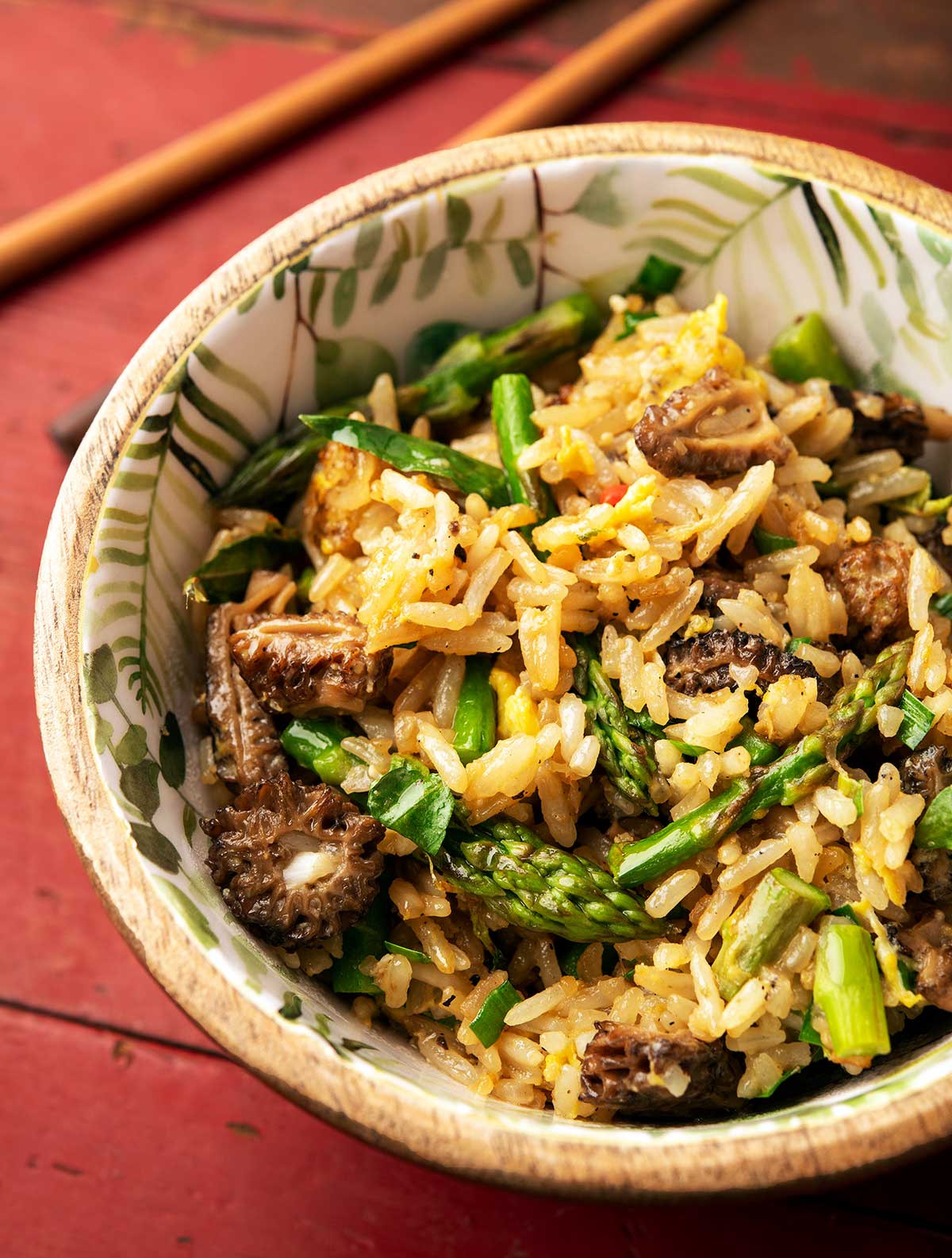 Close up of a bowl of mushroom fried rice with morels and asparagus. 