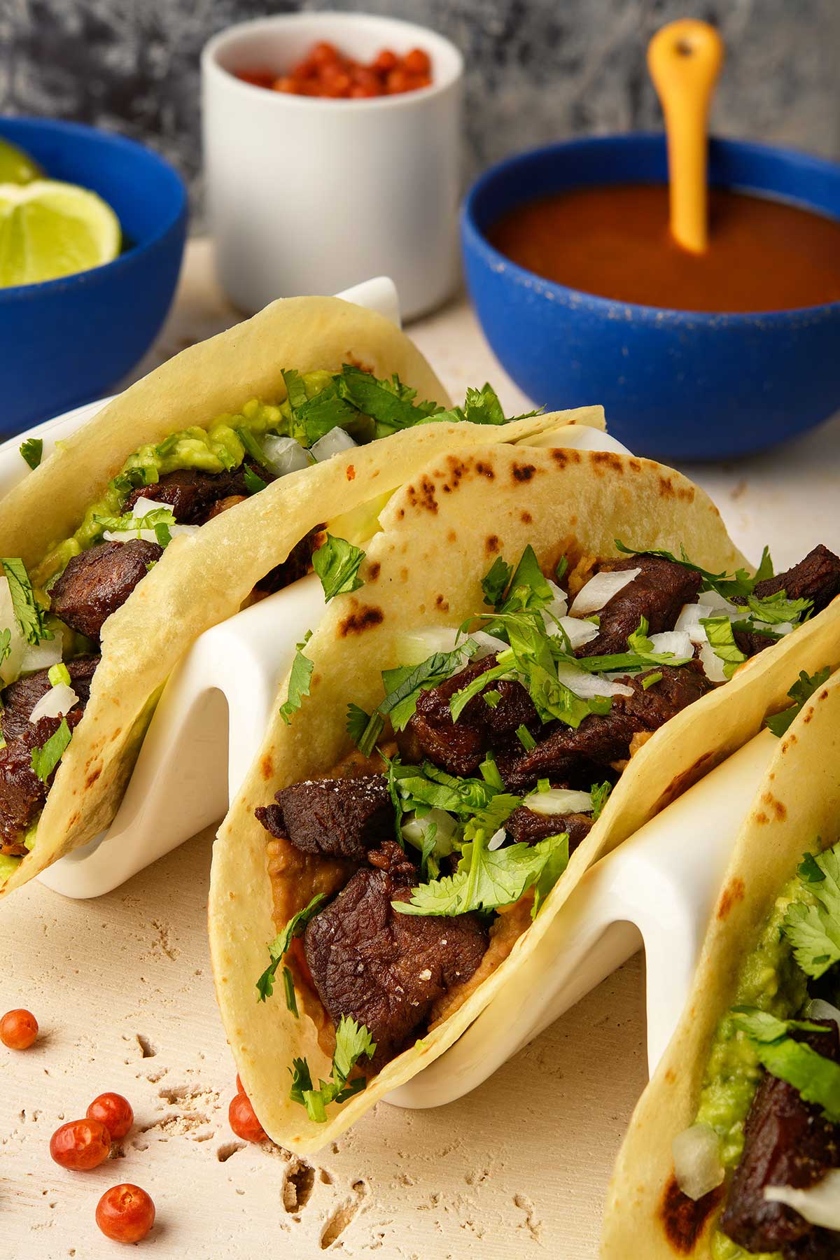 Closeup of chicharron de ribeye in flour tortillas on a taco holder. 