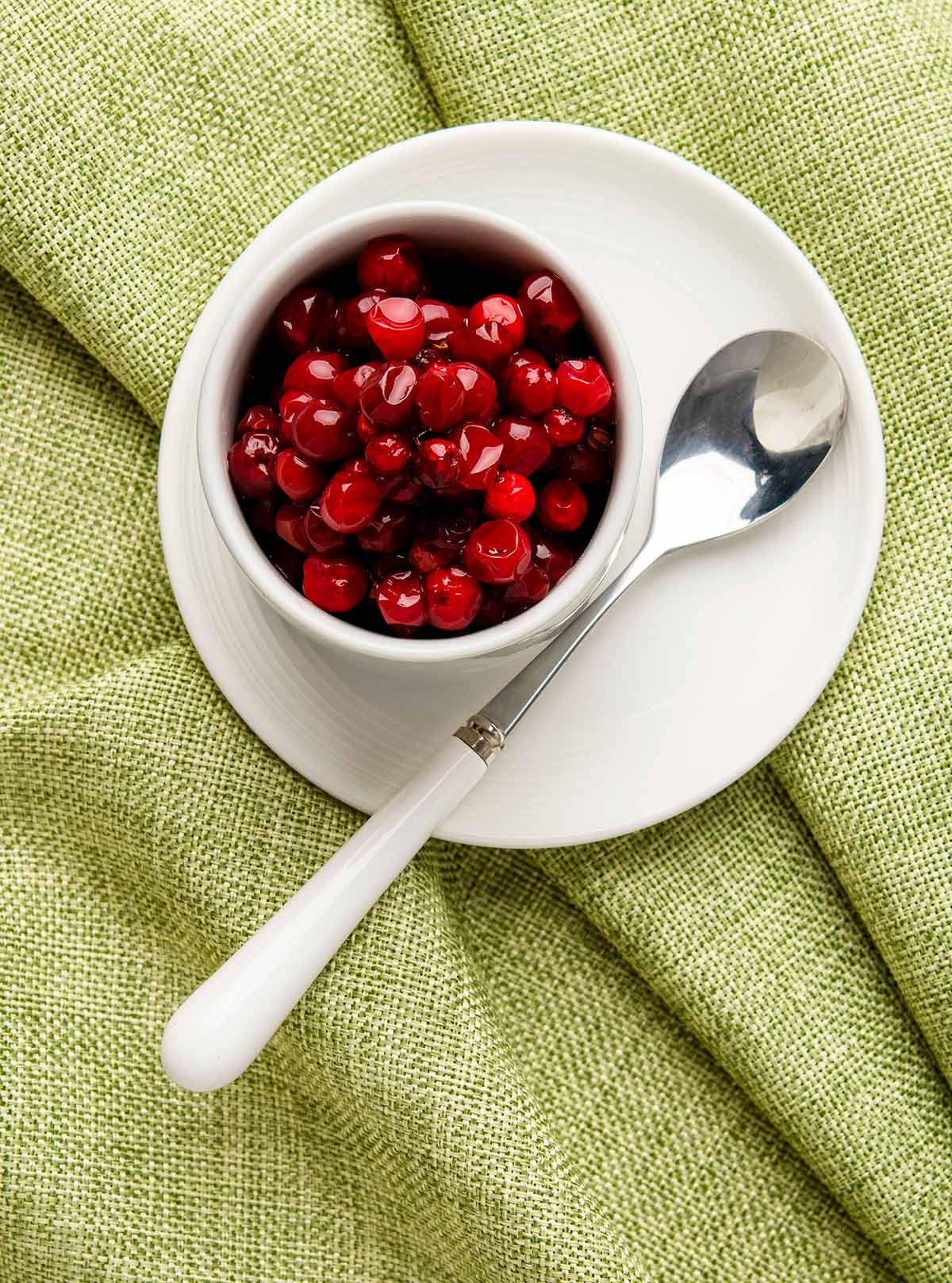 Overhead view of a bowl of sugared lingonberries. 