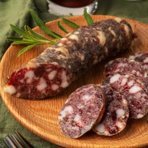 A link of venison salami sliced on a plate.