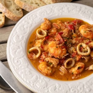 A bowl of zarzuela de mariscos with bread.