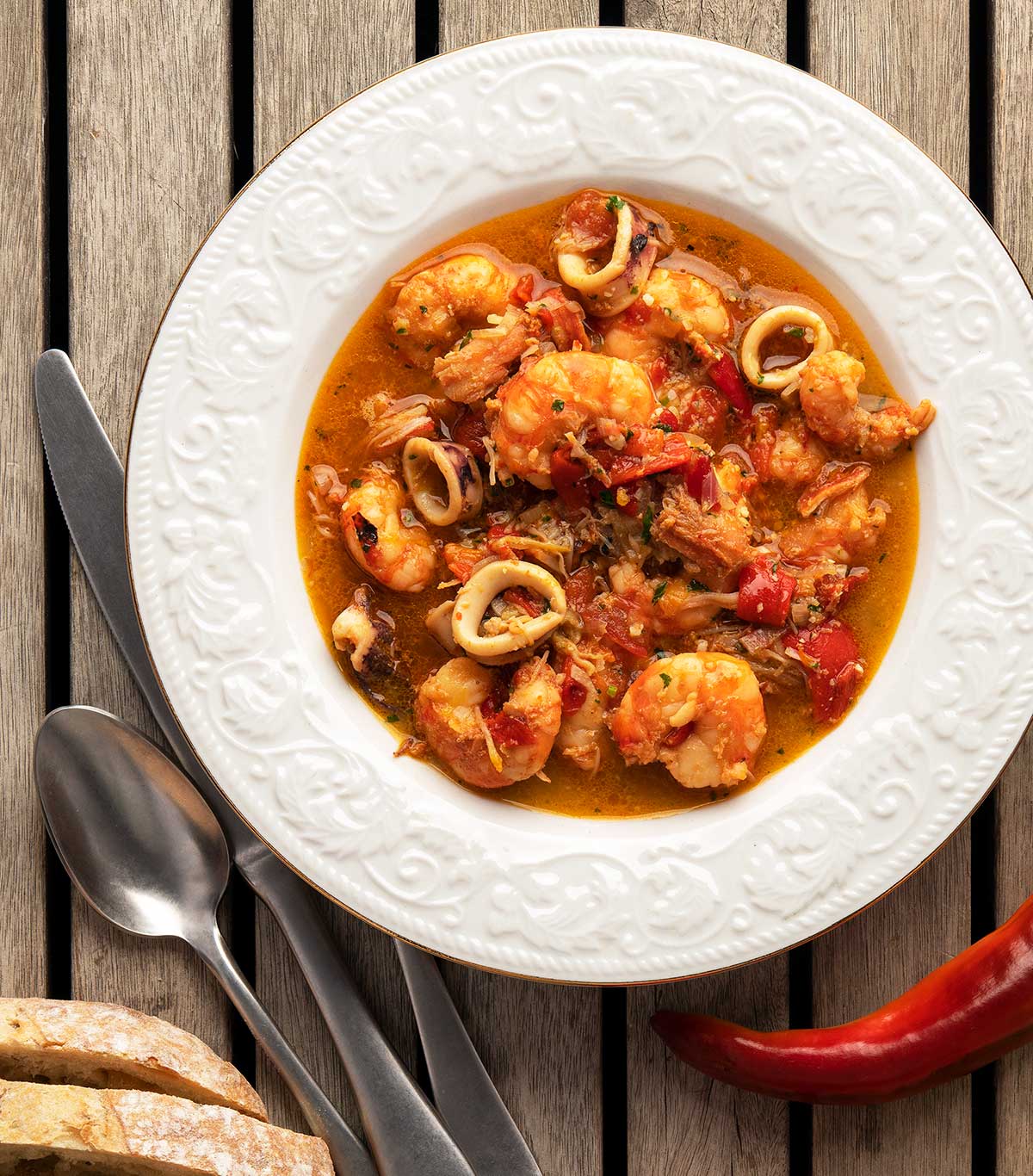 A bowl of zarzuela de mariscos with shrimp, crab and squid. 