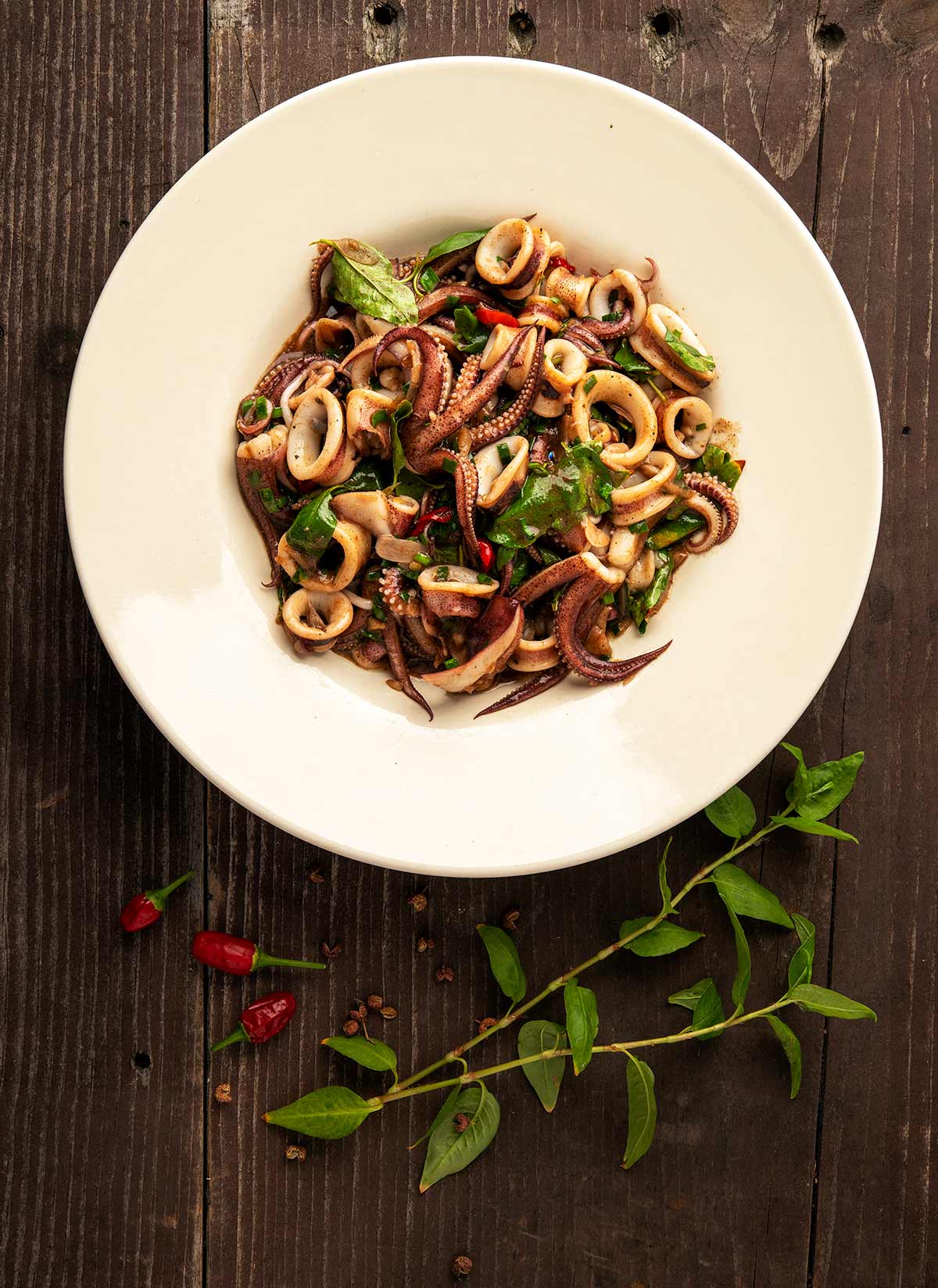 A big bowl of squid stir fry  with chiles and herbs. 