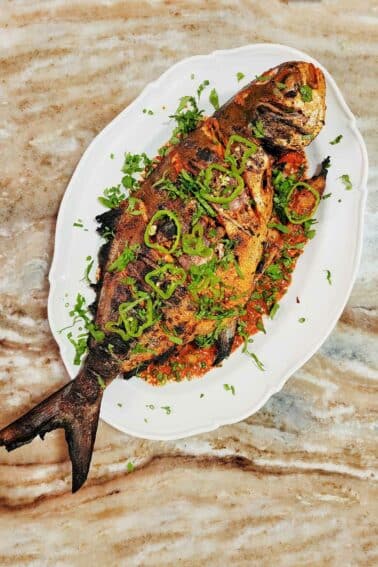 A grilled pompano on a plate.